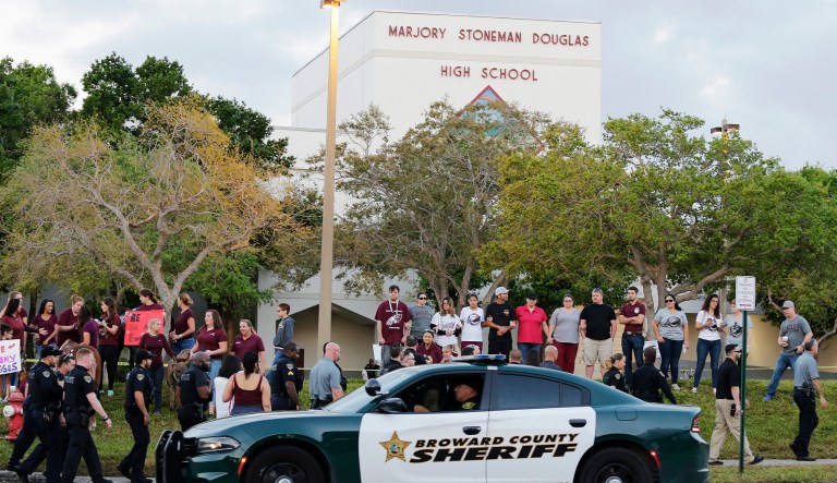 A police car drives by Marjory Stoneman Douglas High School in Parkland, Fla. 