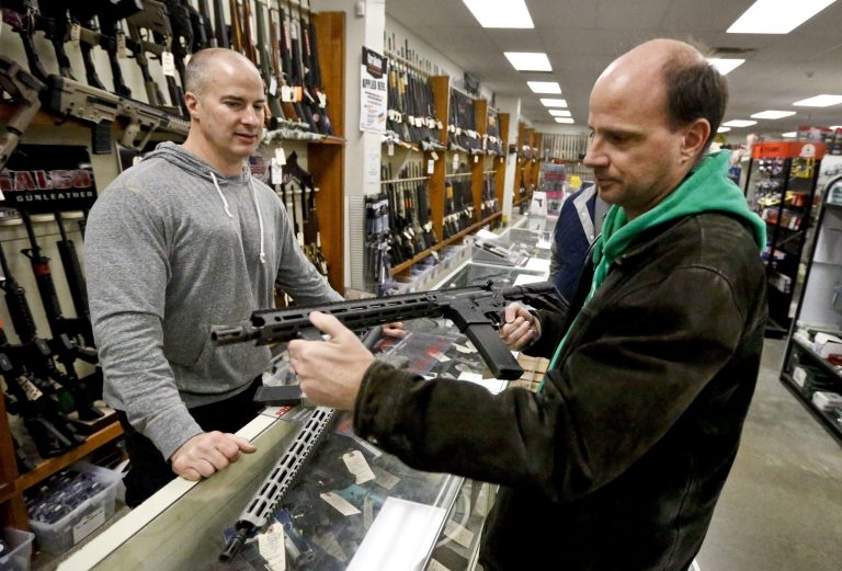 Wes Morosky, owner of Duke's Sport Shop (pictured left), helps Ron Detka as he shops for a rifle on March 2 at his store.
