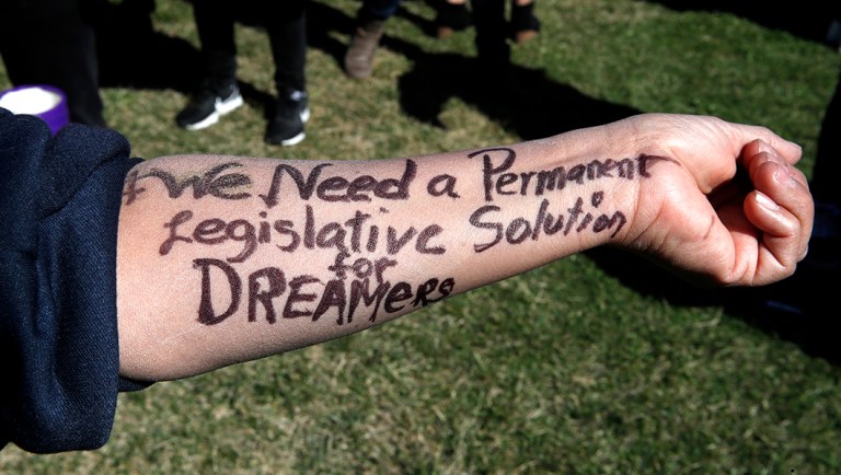A protester displays, "#We need a permanent legislative solution for Dreamers," written on her arm, as part of a gathering supporting recipients of the Deferred Action for Childhood Arrivals.
