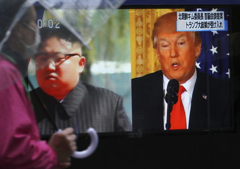 A man walks past a public TV screen showing North Korean leader Kim Jong Un, left, and President Trump, right, in Tokyo.