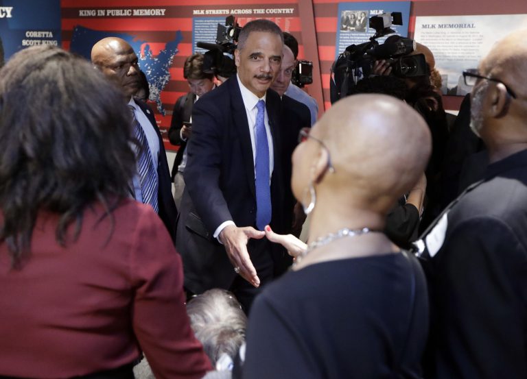 Former U.S. Attorney General Eric Holder, center, greets people as he tours an exhibit at the National Civil Rights Museum Monday, April 2, 2018, in Memphis, Tenn. The museum was formerly the Lorraine Motel, where Rev. Martin Luther King Jr. was assassinated April 4, 1968.