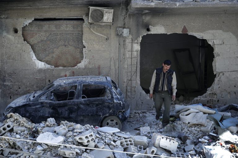 In this Monday, April 16, 2018 photo, man walks just meters away from where the alleged chemical weapons attack occurred in the town of Douma, the site of a suspected chemical weapons attack, near Damascus, Syria. The survivors blamed the attack on the Army of Islam, the powerful rebel group that controlled the town before it was taken over by Syrian government forces this week, although they did not offer evidence to back up their claims.