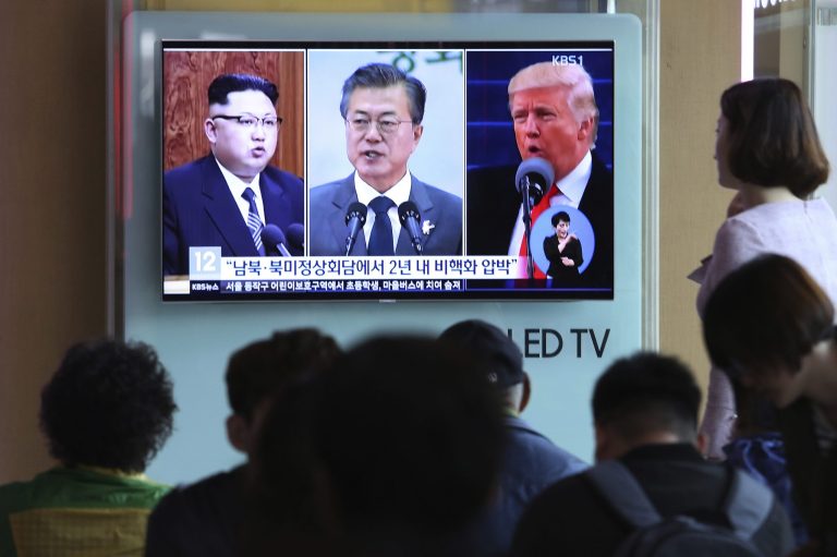 FILE - In this Wednesday, April 18, 2018, file photo, people watch a TV screen showing file footage of U.S. President Donald Trump, right, South Korean President Moon Jae-in and North Korean leader Kim Jong Un, left, during a news program at the Seoul Railway Station in Seoul, South Korea. The upcoming meeting between the leaders of the rival Koreas will be the ultimate test of Moon âs belief that his nation should lead international efforts to deal with North Korea.The signs read: " Summit between South and North Korea, the United States and North Korea." (AP Photo/Ahn Young-joon, File)