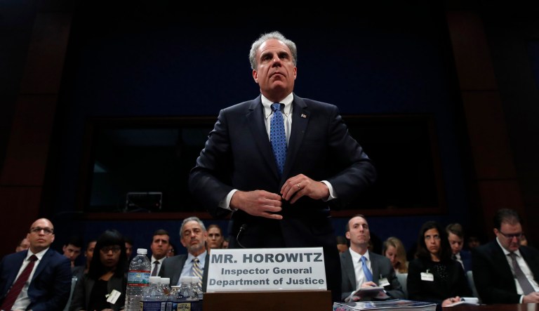 Department of Justice Inspector General Michael Horowitz adjusts his coat before being sworn in for a hearing.
