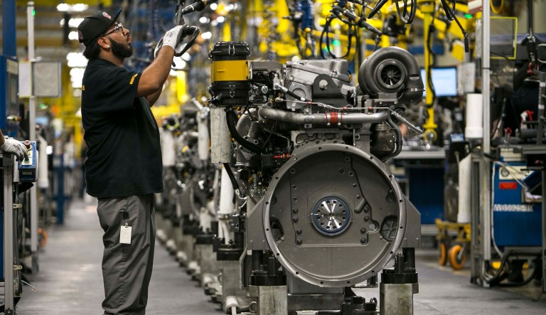 In this June 13, 2018, photo, Mike Gomez uses tools to assemble an engine at Caterpillar's engine manufacturing plant in Seguin, Texas. Caterpillar is part of a broader heavy machinery and equipment manufacturing industry in Texas that employs about 90,000 people and shipped more than $40 billion in industrial machinery to international buyers last year, making it the state's second leading export after petroleum and accounting for 16 percent of all Texas exports.