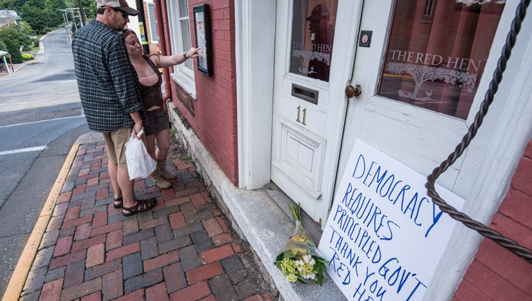 Passersby examine the menu at the Red Hen Restaurant Saturday. (AP Photo/Daniel Lin)
