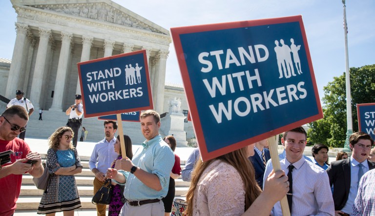 People gather at the Supreme Court awaiting a decision in an Illinois union dues case, Janus vs. AFSCME, in Washington. 