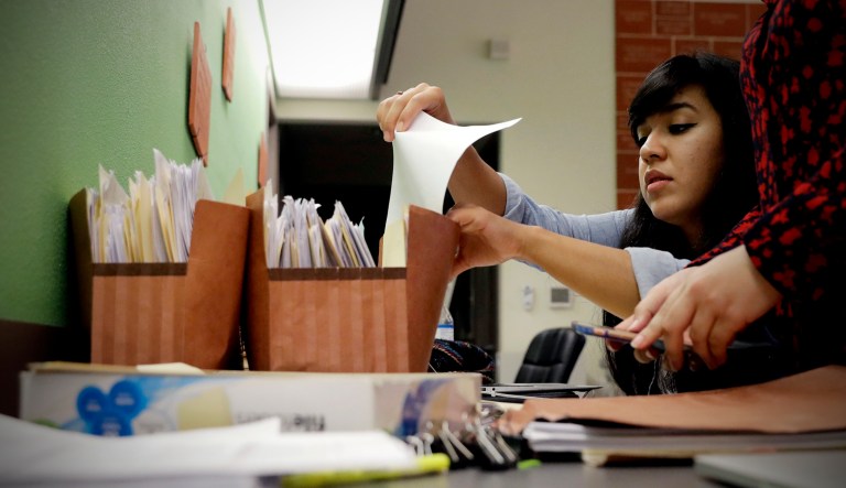 A clerk handles files in an office.