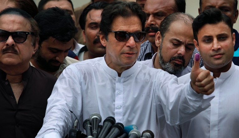 Pakistani politician Imran Khan, chief of Pakistan Tehreek-e-Insaf party, shows his marked thumb after casting his vote at a polling station for the parliamentary elections in Islamabad, Pakistan, Wednesday, July 25, 2018.