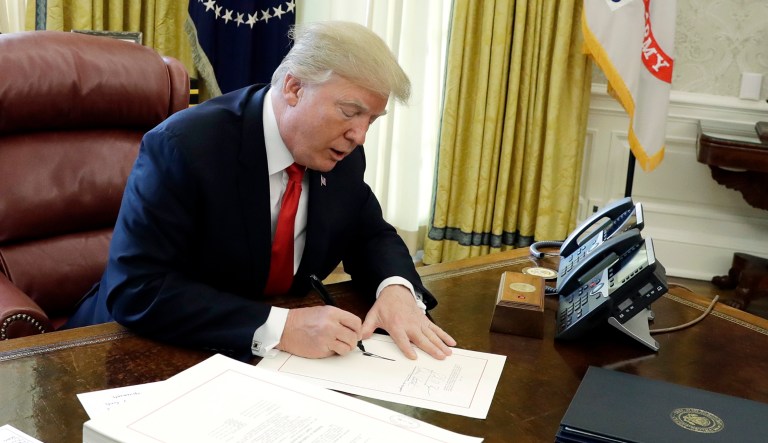 In this 2017 photo, President Trump signs into law a $1.5 trillion tax overhaul package in the Oval Office of the White House in Washington. New rules floated by the Trump administration lay out what kinds of businesses can take a 20 percent deduction against income taxes under the new tax law.