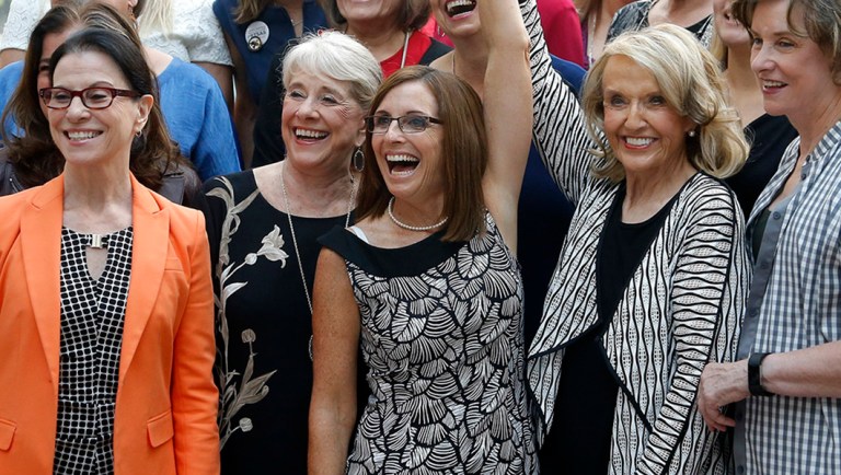 Rep. Martha McSally, R-Ariz., third from left, laughs as she gets her arm raised by former Arizona Republican Gov. Jan Brewer, third from right, as they pose for a photograph with members of the Women's Coalition after a news conference at a campaign event for McSally's U.S. Senate primary race Wednesday, Aug. 15, 2018, in Phoenix. McSally, Kelli Ward and former Maricopa County Sheriff Joe Arpaio are vying for the Republican nomination, but there are no plans currently for a televised debate for the Republican candidates, on the Democratic side, Rep. Kyrsten Sinema and activist Deedra Abboud haven't had a televised debate either. (AP Photo/Ross D. Franklin)