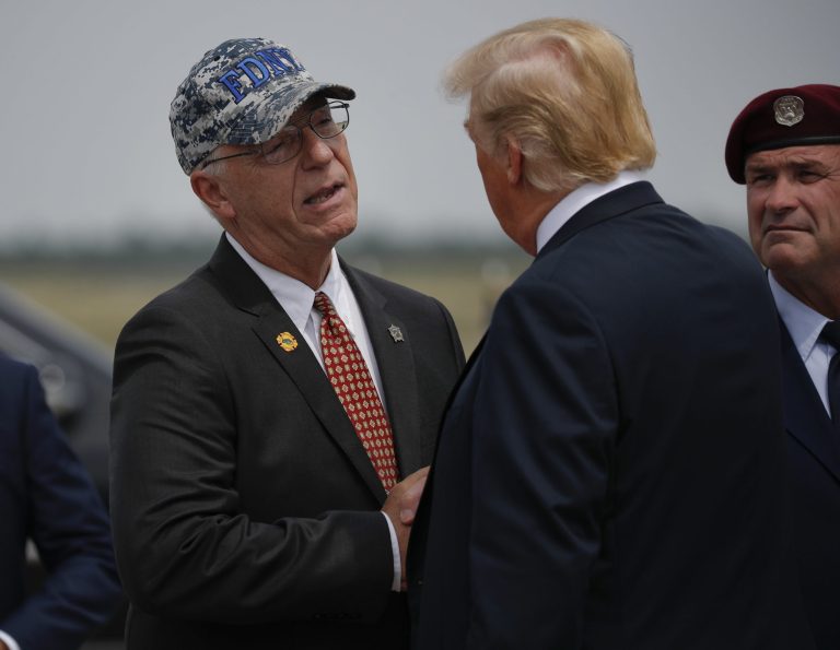 President Donald Trump, right, is greeted by John Raguso, left, a Gold Star Father, on the tarmac up his arrival at Francis S. Gabreski Airport in Westhampton, NY., Friday, Aug. 17, 2018. Raguso's son, Christopher Raguso, was a member of the New York Air National Guard who died in a helicopter crash in western Iraq in March 2018.