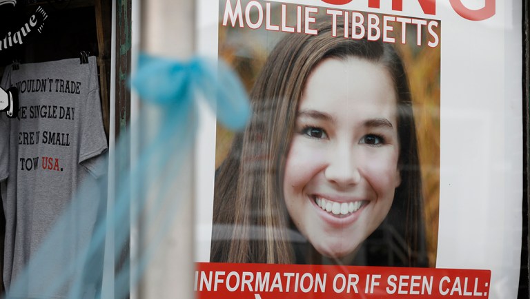 A poster for missing University of Iowa student Mollie Tibbetts hangs in the window of a local business.