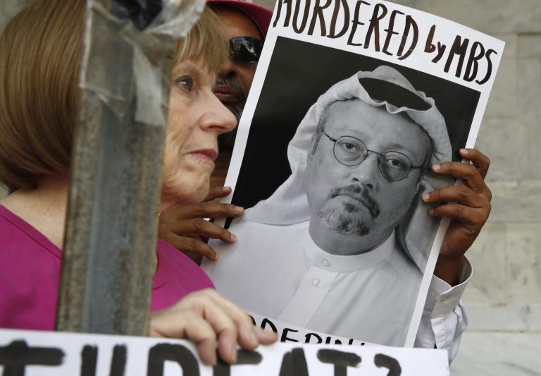 People hold signs during a protest at the Embassy of Saudi Arabia about the disappearance of Saudi journalist Jamal Khashoggi.