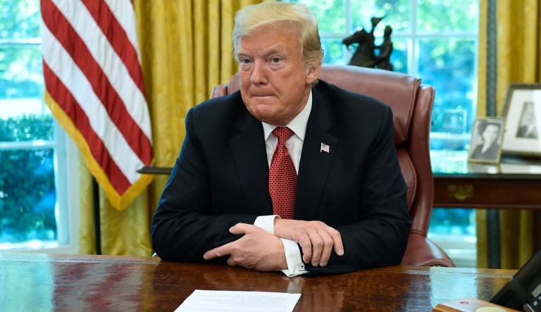 President Donald Trump waits for reporters to leave the Oval Office of the White House in Washington, Wednesday, Oct. 17, 2018, following a meeting with workers. The meeting with workers was on, "Cutting the Red Tape, Unleashing Economic Freedom." 