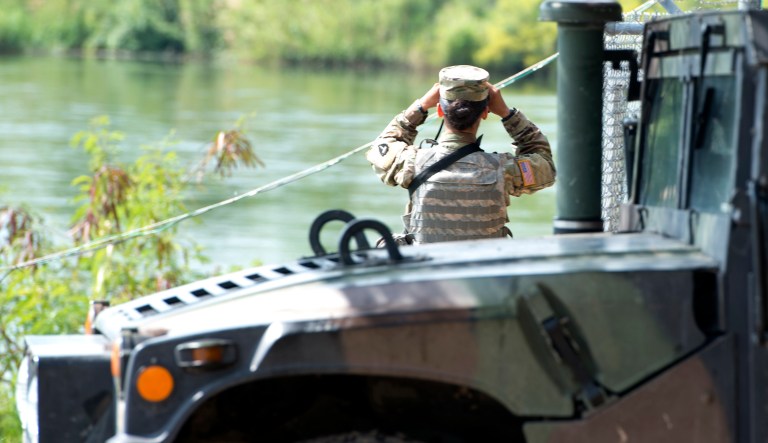 A soldier from the Texas National Guard scans the shores of the Rio Grande in Starr County, Texas.