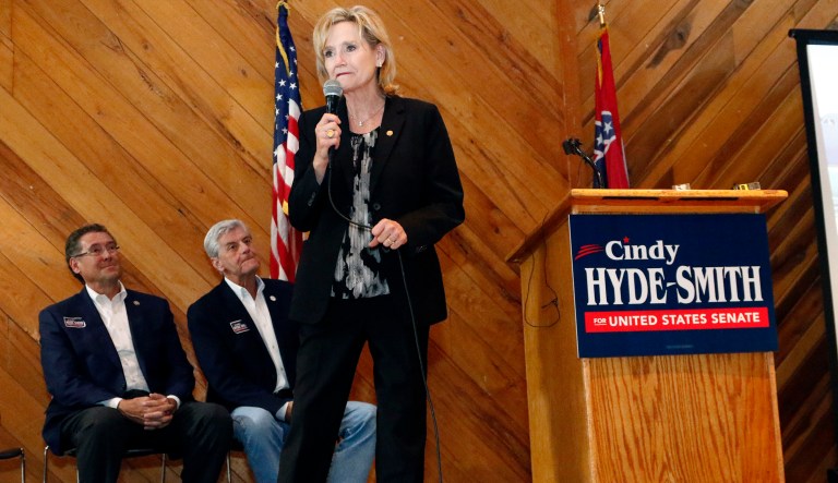With U.S. Rep. Gregg Harper, R-Miss., left, and Gov. Phil Bryant, in attendance, U.S. Sen. Cindy Hyde-Smith, R-Miss., right, addresses a gathering of supporters in Jackson, Miss., Monday, Nov. 5, 2018. Hyde-Smith hopes to get elected to serve the last two years of the six-year term vacated when Republican Thad Cochran retired for health reasons. State Sen. Chris McDaniel, R-Ellisville, former military intelligence officer Tobey Bernard Bartee and former Democratic congressman and Agriculture Secretary under the Clinton Administration Mike Espy are also running in the non-partisan race.