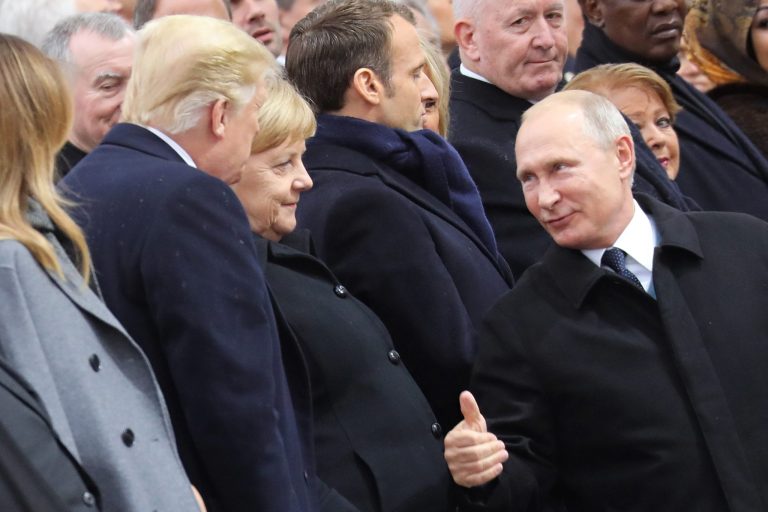 Russian President Vladimir Putin talks with German Chancellor Angela Merkel and US President Donald Trump as they attend a ceremony at the Arc de Triomphe in Paris, as part of commemorations marking the 100th anniversary of the 11 November 1918 armistice, ending World War I, Sunday, Nov. 11, 2018.