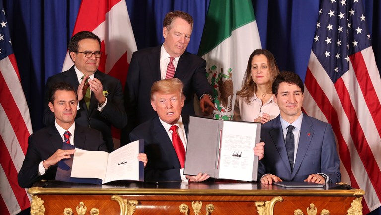 President Trump, center, sits between Canada's Prime Minister Justin Trudeau, right, and Mexico's President Enrique Pena Nieto after they signed a new United States-Mexico-Canada Agreement.