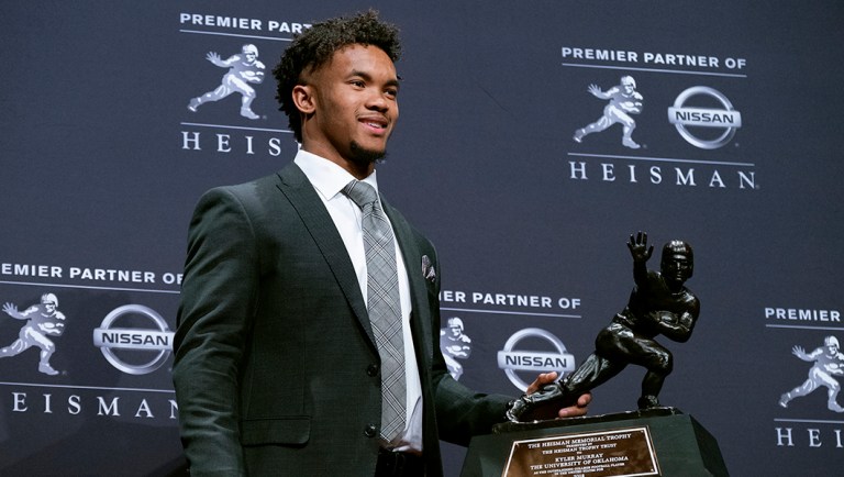 Oklahoma quarterback Kyler Murray holds the Heisman Trophy after winning the award.