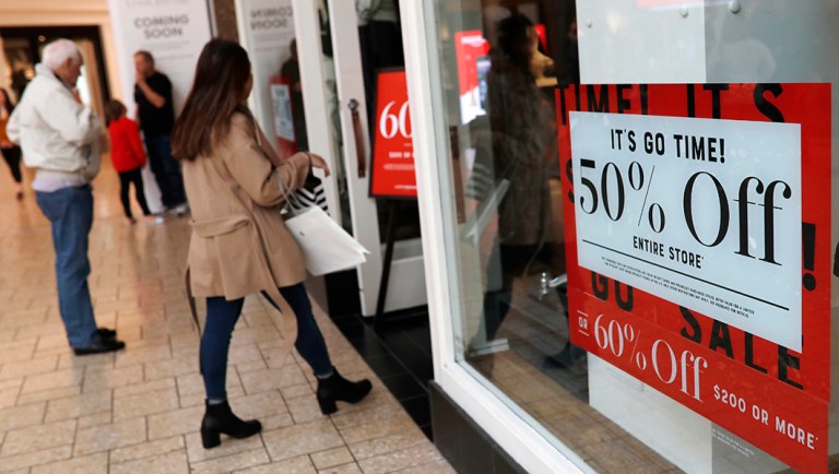 Discount placards stand in the window of a clothing store as last-minute shoppers finish up their Christmas gift lists.
