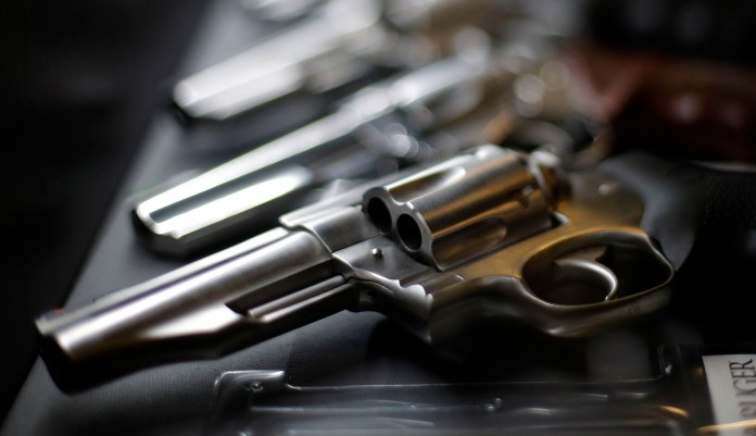 Handguns for sale are displayed at a store.