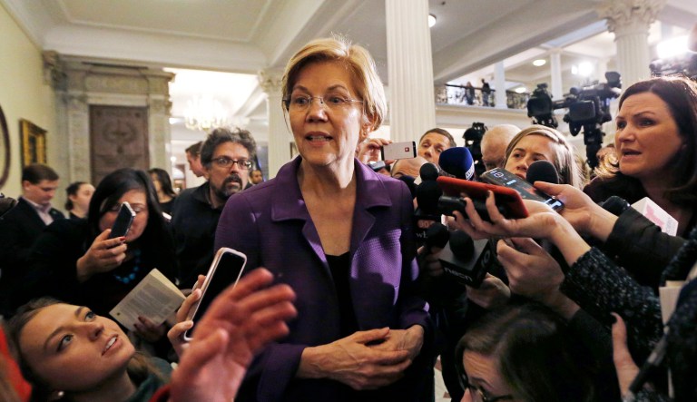 Sen. Elizabeth Warren, D-Mass., is surrounded by reporters at the Massachusetts Statehouse, Wednesday, Jan. 2, 2019, in Boston. Warren has taken the first major step toward launching a widely anticipated campaign for the presidency, hoping her reputation as a populist fighter can help her navigate a Democratic field that could include nearly two dozen candidates.