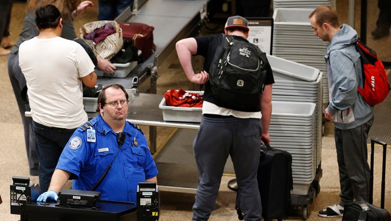 A TSA worker helps passengers at the Salt Lake City International Airport.