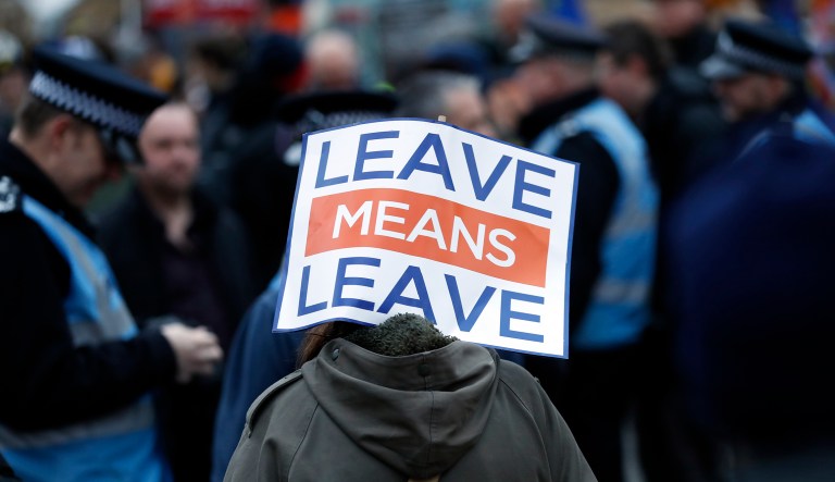 A pro-leave supporter carries a placard during demonstrations in London, Tuesday, Jan. 29, 2019. Britain's Parliament is set to vote on competing Brexit plans, with Prime Minister Theresa May desperately seeking a mandate from lawmakers to help secure concessions from the European Union.