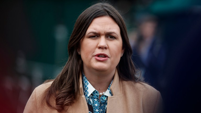 White House press secretary Sarah Sanders talks with reporters outside the White House.