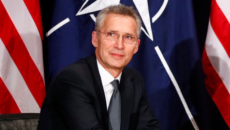 NATO's Secretary General Jens Stoltenberg, left, shake hands.