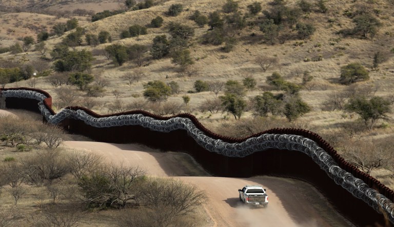 A Customs and Border Control agent patrols on the US side of a razor-wire-covered border wall along the Mexico east of Nogales, Ariz. Saturday, March 2, 2019. 