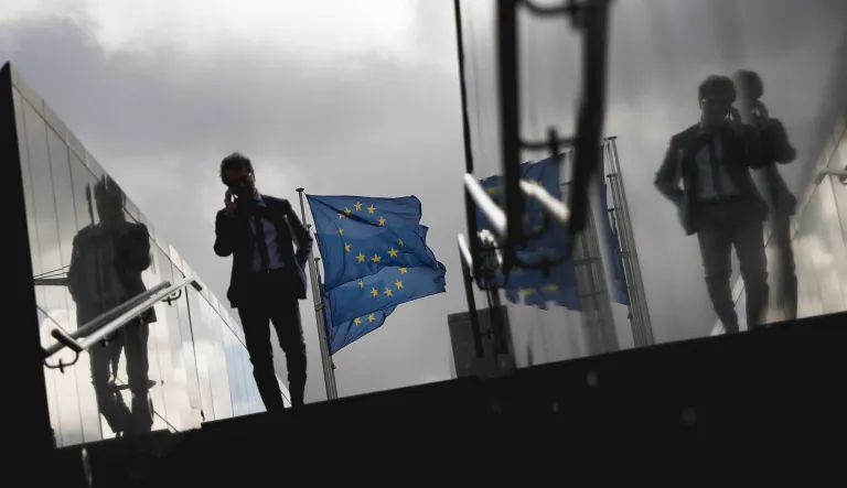 A man walks past European Union flags outside the European Commission headquarters in Brussels.