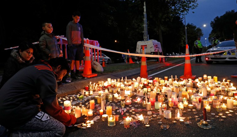 A mourner lights a candle during a vigil to commemorate victims of Friday's shooting, outside the Al Noor mosque in Christchurch, New Zealand, Monday, March 18, 2019. Three days after Friday's attack, New Zealand's deadliest shooting in modern history, relatives were anxiously waiting for word on when they can bury their loved ones.