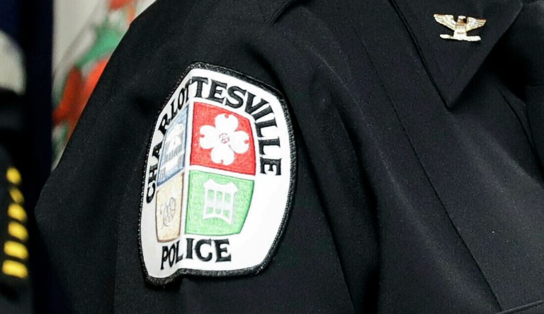 A Charlottesville police patch is shown.