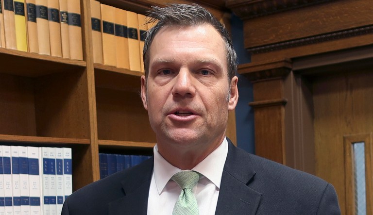 In this Nov. 30, 2018 photo, then Kansas Secretary of State Kris Kobach responds to questions from reporters in Topeka, Kan. 