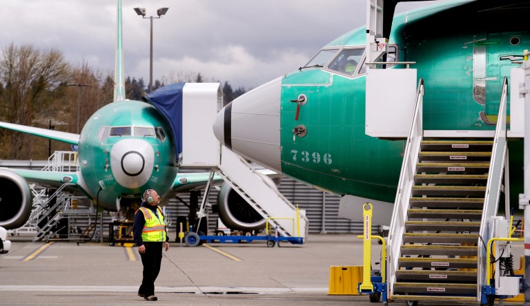 A worker looks up at a parked Boeing 737 Max 8 built for Jet Airways as another 737 Max 8 made for Shenzhen Airlines stands behind at a Boeing Co. production facility in Renton, Wash.