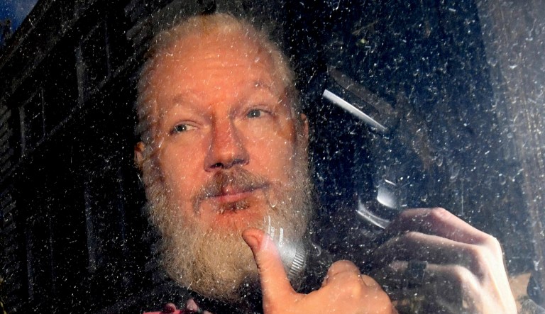 Julian Assange gestures as he arrives at Westminster Magistrates' Court in London, after the WikiLeaks founder was arrested by officers from the Metropolitan Police and taken into custody Thursday.