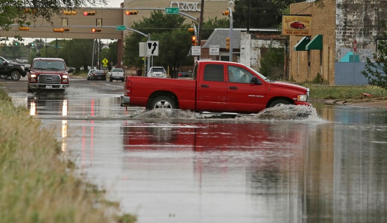 A vehicle drives through a flooded section of Muskingum Avenue on Saturday, April,13, 2019, in Odessa, Texas.