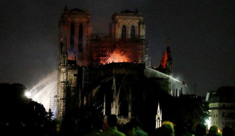 People watch Notre Dame cathedral burning in Paris, Monday.