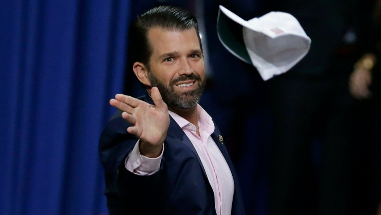 Donald Trump Jr. tosses hats to the crowd before speaking ahead of his father.