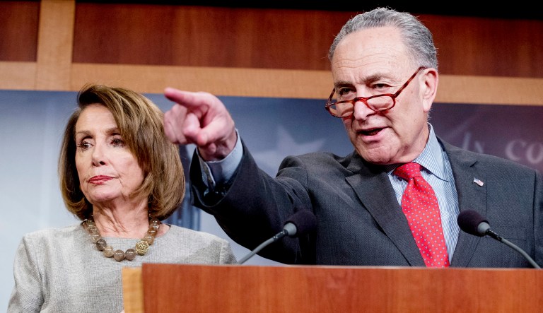 Senate Minority Leader Sen. Chuck Schumer of N.Y., accompanied by Speaker Nancy Pelosi of Calif., left, calls on a reporter during a news conference on Capitol Hill in D.C.