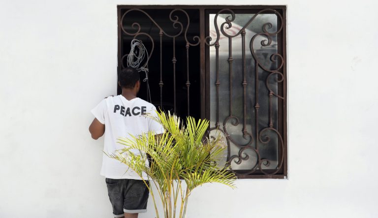 Teenage migrant dies in US custody In this Wednesday, May 1, 2019, photo, an asylum seeker stands at a church window as he waits at a shelter in Reynosa, Mexico. The turning away of most asylum seekers by U.S. officers standing at the bridge connecting Reynosa, Mexico, to McAllen, Texas, has created more business for the criminal networks known to control most aspects of life here.