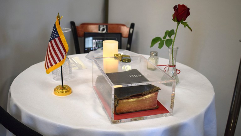 This Monday, May 6, 2019 photo provided by the Manchester VA Medical Center shows a Bible as part of a memorial table display at the veterans hospital in Manchester, N.H.