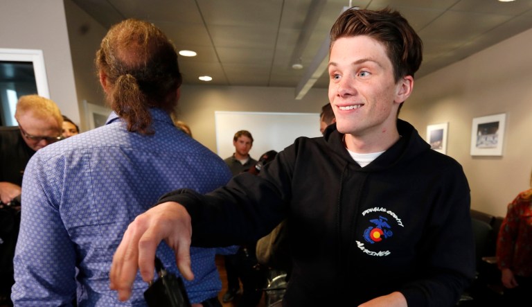 Brendan Bialy hands back a microphone after he spoke about his role in stopping the attack at the STEM School Highlands Ranch during a news conference Wednesday in Englewood, Colo.