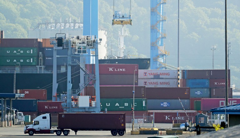 A truck drives near cargo containers in Tacoma, Wash.