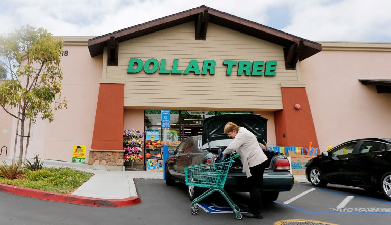A shopper searches her purse outside a Dollar Tree store in Encinitas, Calif. 
