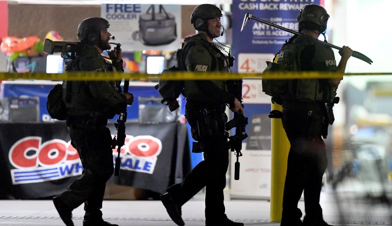 Heavily armed police officers exit the Costco following a shooting inside the wholesale warehouse in Corona, Calif.,  Friday, June 14, 2019.  A gunman opened fire inside the store during an argument,  killing a man, wounding two other people and sparking a stampede of terrified shoppers before he was taken into custody, police said. The man involved in the argument was killed and two other people were wounded, Corona police Lt. Jeff Edwards said. 