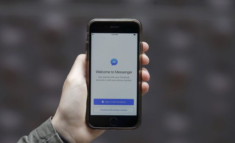 This July 10, 2019, photo shows an Associated Press reporter holding a phone showing the Facebook Messenger app in San Francisco. 