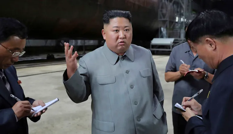 In this undated photo provided on Tuesday by the North Korean government, North Korean leader Kim Jong Un, center, speaks to a small group.
